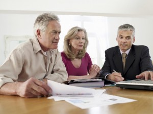 Mature couple sitting at table with financial advisor